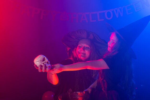 Niño divertido niña y mujer en disfraces de brujas para halloween