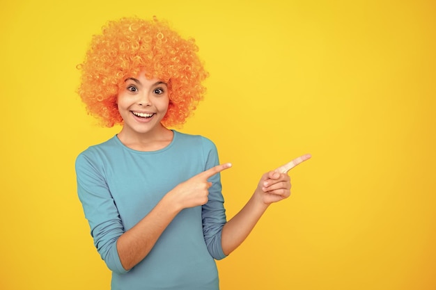 Niño divertido con peluca de pelo rizado Niña linda con cabello elegante Niño con peluca de pelo de payaso pelirrojo brillante Retrato de adolescente feliz Niña sonriente