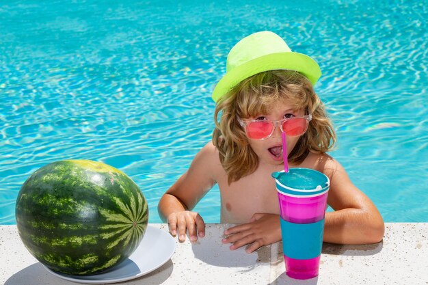 Niño divertido en piscina Niño beber cóctel frutas de verano sandía Cóctel de verano para niños