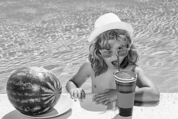 Niño divertido en piscina Niño beber cóctel frutas de verano sandía Cóctel de verano para niños