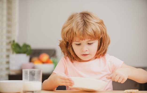 Niño divertido con plato de sopa