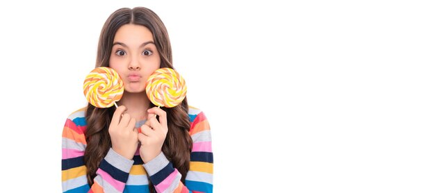 Foto niño divertido en suéter colorido sostenga caramelos de azúcar de piruleta en la tienda de dulces de caramelo de palo niño adolescente con espacio de copia de encabezado de cartel de dulces