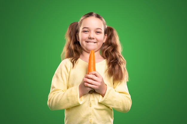 Niño divertido con zanahoria saludable