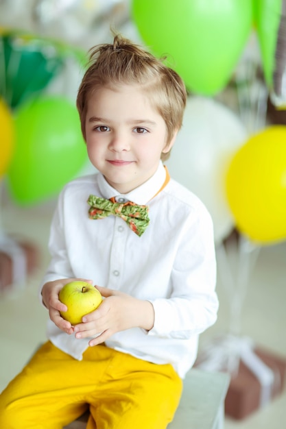 Un niño se divierte y juega con globos en una habitación decorada con colores