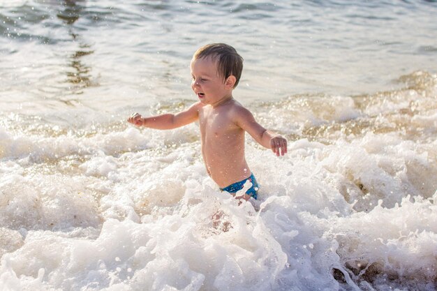 Un niño divirtiéndose en el mar sobre las olas.