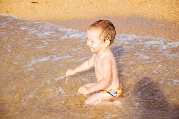 Un niño divirtiéndose en el mar sobre las olas.