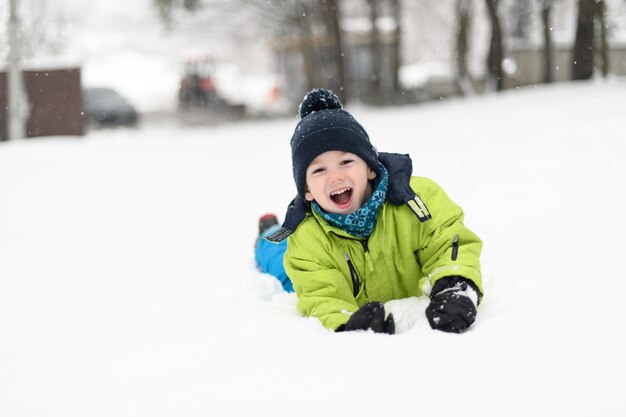 Niño divirtiéndose mientras jugaba en la nieve