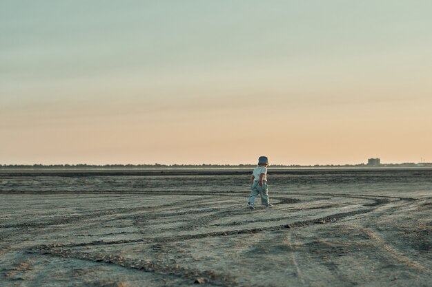 Un niño de dos años camina por el fondo seco del lago.