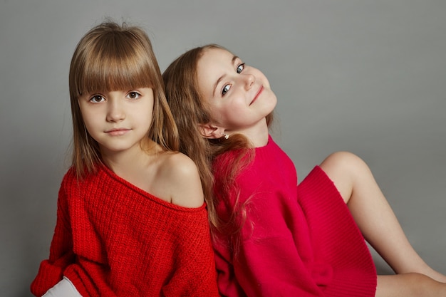 Niño de dos chicas de moda en chaquetas rojas.