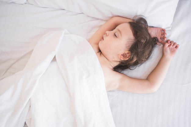 El niño duerme dulcemente en la cama durmiendo niños en la cama de los padres en el que el niño duerme profundamente ...