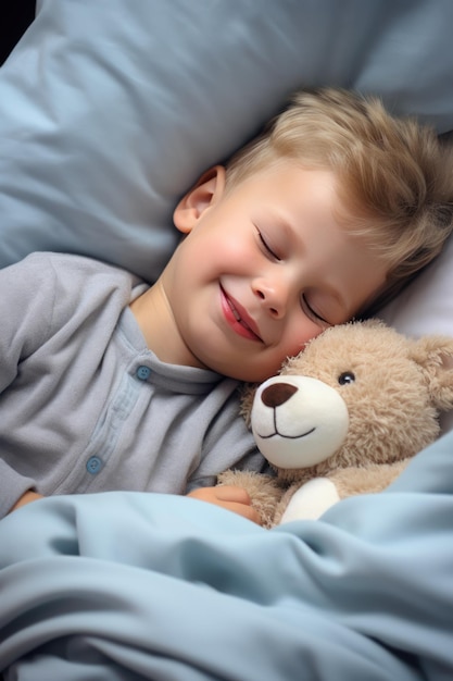 niño duerme dulcemente en la cama con un oso de juguete en sus brazos bajo la manta