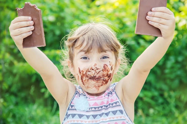 Foto un niño dulce come chocolate. enfoque selectivo