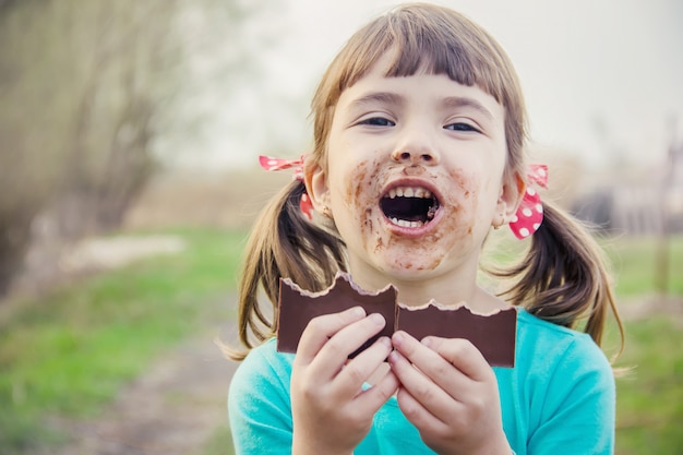 Un niño dulce come chocolate. Enfoque selectivo