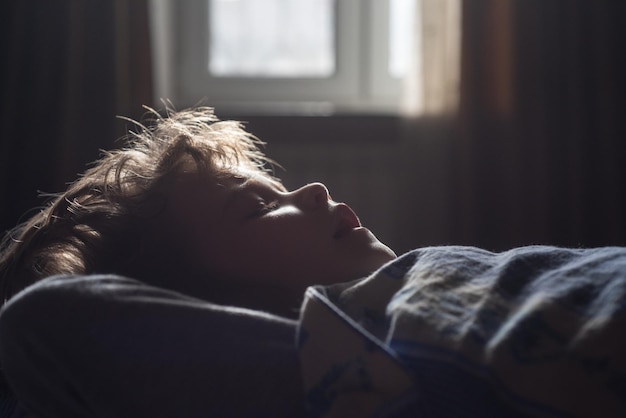 Niño durmiendo en la cama luces de la mañana