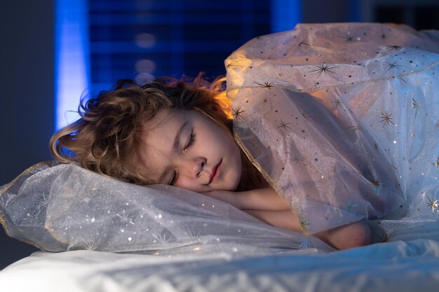 Niño durmiendo en la cama niño durmiendo bajo la manta acostado en la almohada niño descansando durmiendo disfrutando de la salud