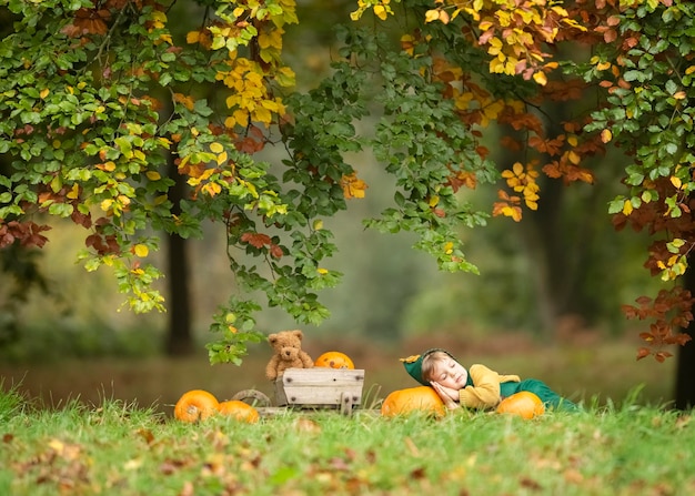 Niño durmiendo en el campo durante el otoño