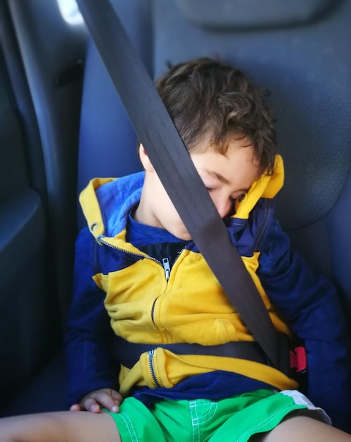 Foto niño durmiendo en el coche.