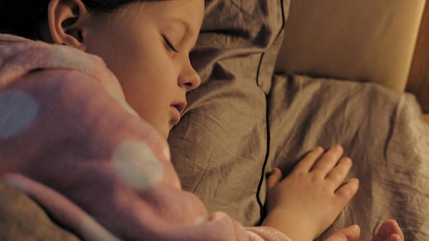 Niño durmiendo niño descansa pacífica niña pequeña en la cama