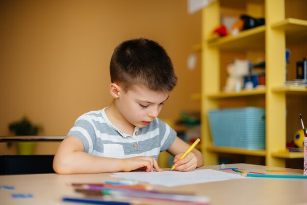 Un niño en edad escolar hace la tarea en casa. Entrenamiento en la escuela.