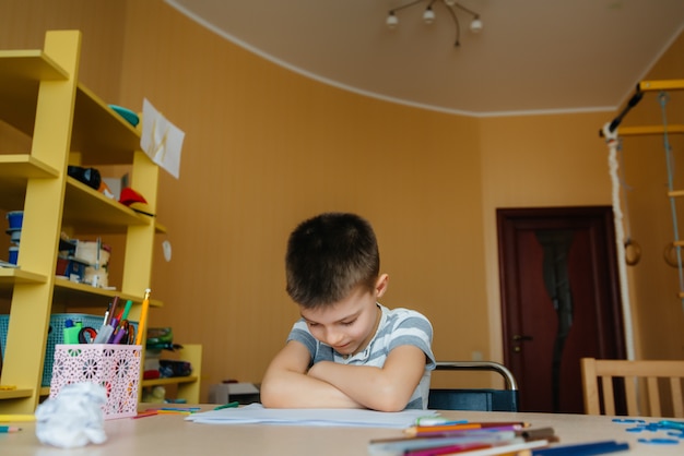 Un niño en edad escolar hace la tarea en casa. Entrenamiento en la escuela.