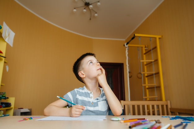 Un niño en edad escolar hace la tarea en casa. Entrenando en la escuela