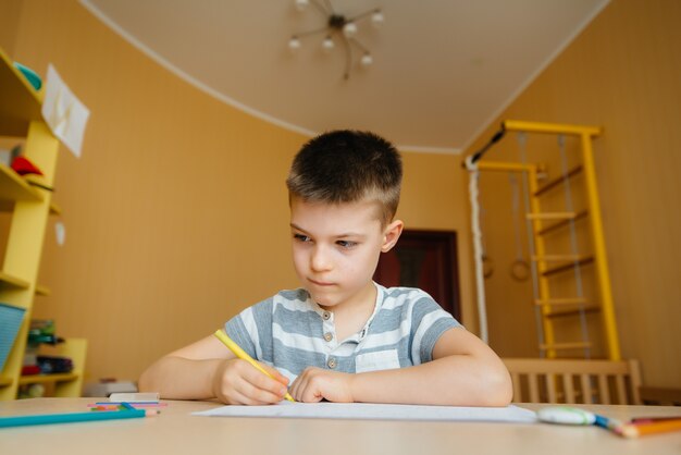 Foto un niño en edad escolar hace la tarea en casa. entrenando en la escuela