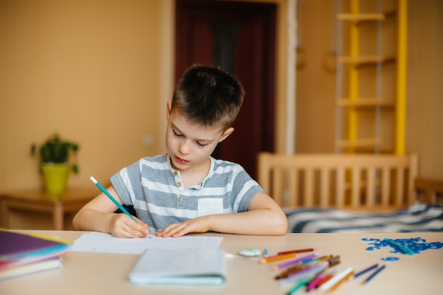 Un niño en edad escolar hace la tarea en casa. Entrenando en la escuela