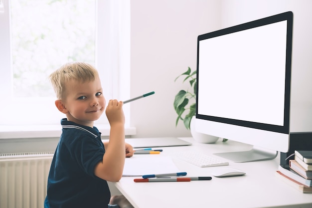 Niño en edad preescolar que usa tecnología informática en el desarrollo temprano o entretenimiento en casa