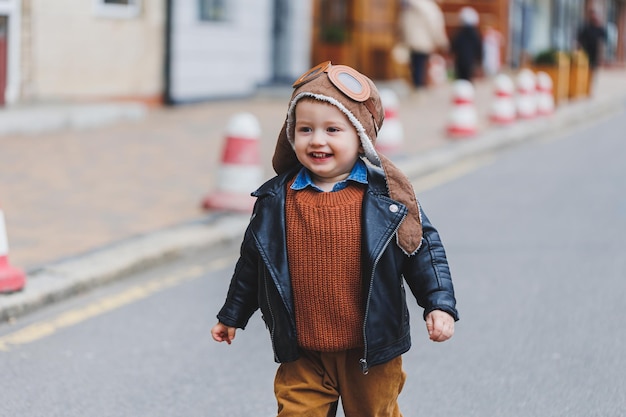 Niño elegante de 3 años con chaqueta de y marrones camina por la calle niño moderno moda infantil feliz | Foto Premium