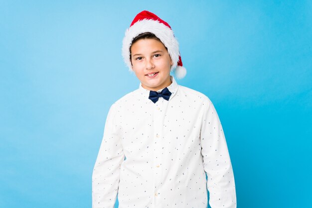 Niño elegante con un sombrero de santa en un día de navidad