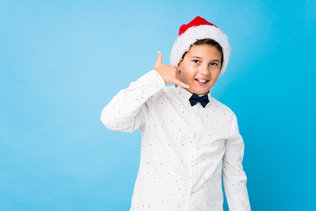 Niño elegante con un sombrero de santa en un día de navidad