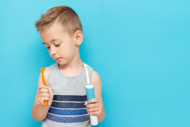 El niño elige entre cepillos de dientes eléctricos y convencionales