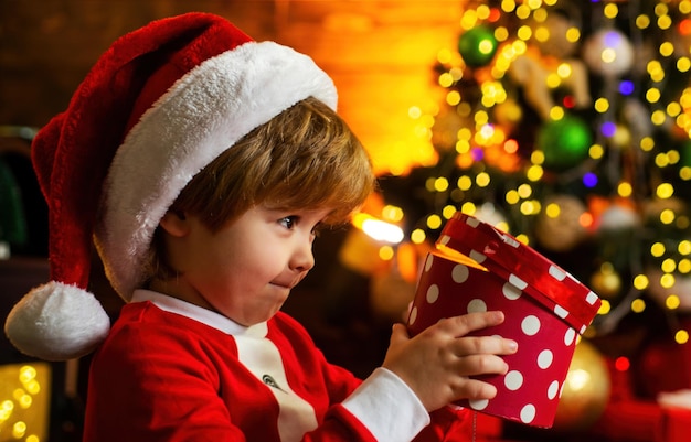 Foto niño emocionado abriendo un regalo de navidad presente