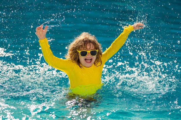 Niño emocionado disfrutar de las vacaciones de verano y vacaciones de verano en la piscina niño feliz jugando en el se