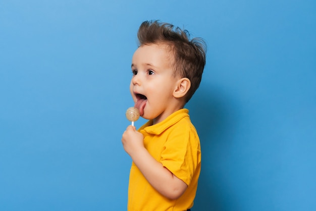 Un niño encantador sosteniendo una piruleta. Prevención de la caries infantil