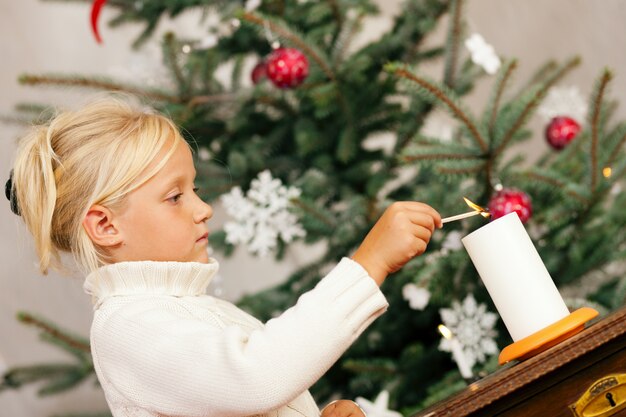 Niño encendiendo velas navideñas