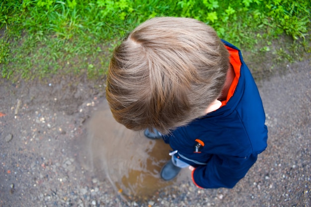 niño se encuentra en un charco