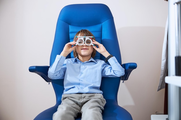 Niño enderezando las gafas de prueba en la cabeza