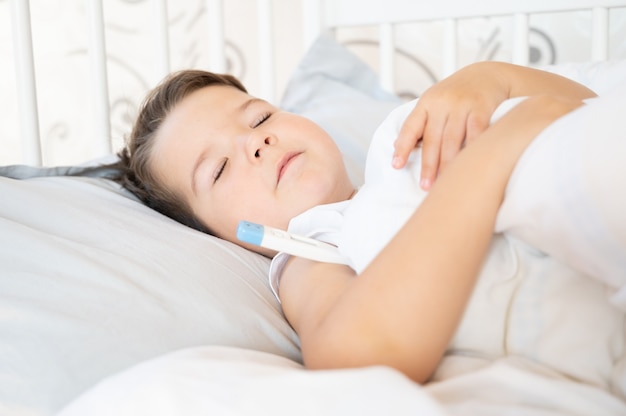 Niño enfermo durmiendo en la cama.