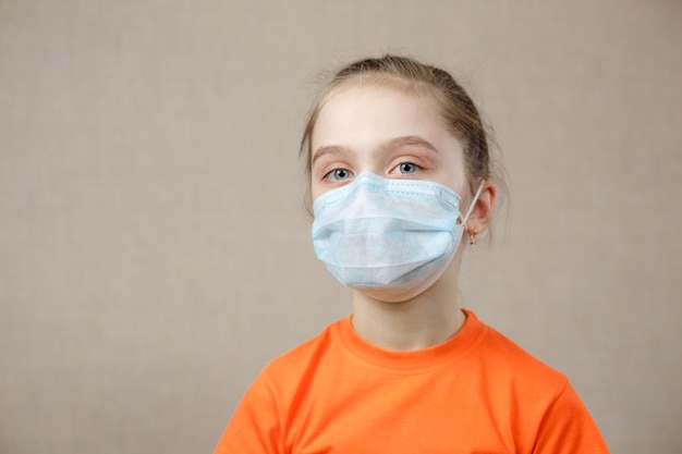 Foto niño enmascarado - protección contra virus. niña caucásica con máscara para el covid 19. armas biológicas. pandemia epidémica.