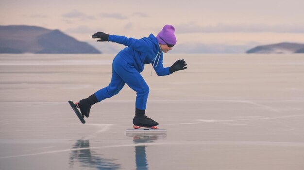 El niño entrena en patinaje de velocidad profesional sobre hielo La niña patina en el invierno en ropa deportiva traje de gafas deportivas Niños patinaje de velocidad pista corta larga deporte infantil Cámara lenta al aire libre