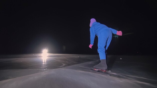 El niño entrena en patinaje de velocidad sobre hielo El patinaje nocturno La niña patina en el invierno en ropa deportiva gafas deportivas Al aire libre cámara lenta