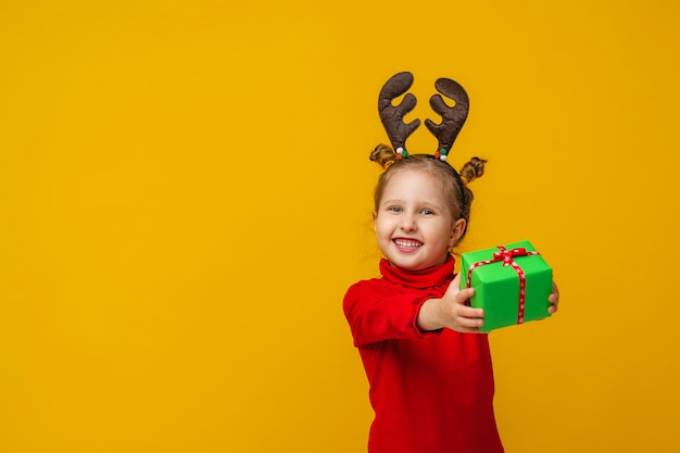 Foto niño es feliz y tiene un regalo en sus manos