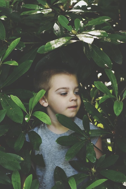 Foto niño escondido al aire libre