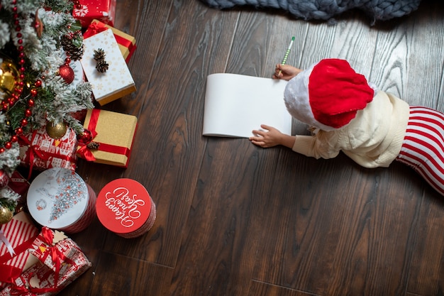 Foto un niño escribe una carta a santa claus