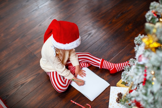 Foto un niño escribe una carta a santa claus