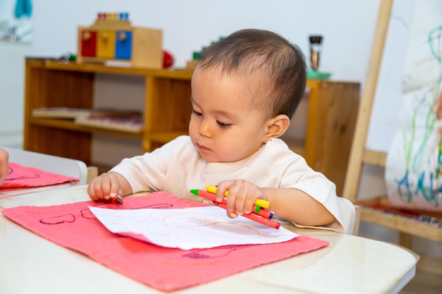 Niño escribiendo con lápiz de aceite sobre papel