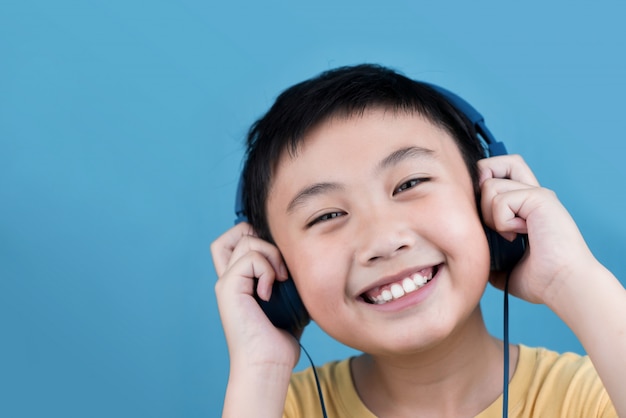 Niño escuchando música en azul