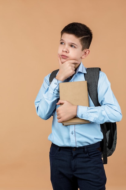 niño de escuela alegre sosteniendo un pequeño libro