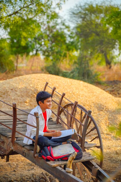 Niño de escuela india / asiática con cuaderno y estudiando